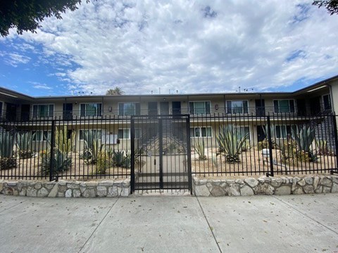 A black iron fence surrounds a building.