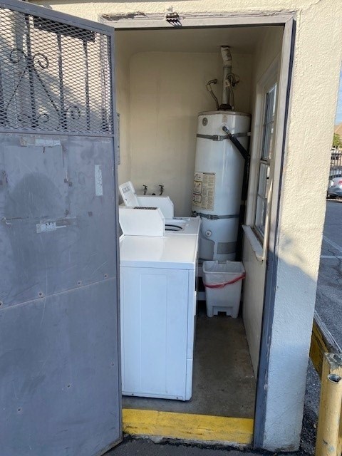 A white washing machine is in a doorway with a grey wall.