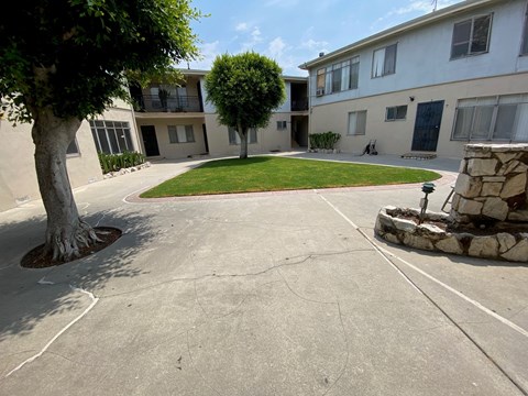 A courtyard with a tree and a stone fireplace.