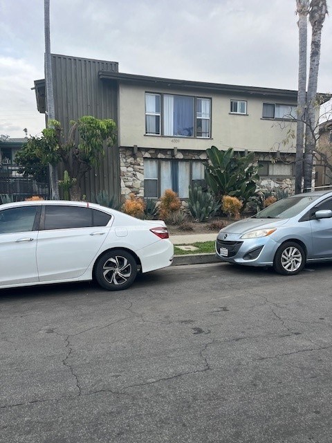 Two cars parked in front of a house.