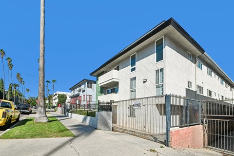 A white building with a black gate in front of it.