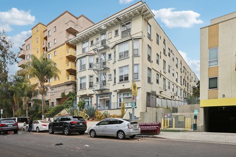 Cars parked in front of a building with a yellow sign on the right.