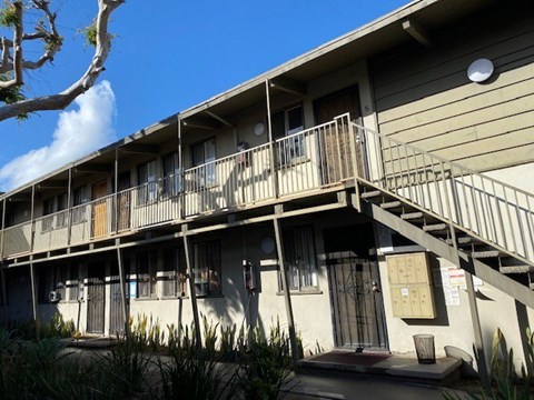 A building with a balcony and stairs leading to the second floor.