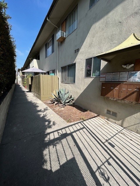 A sunny day in a residential area with apartment buildings and a sidewalk.