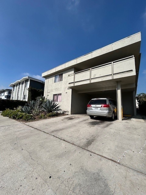 A silver car is parked in a garage door of a building.