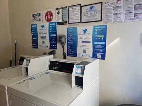 A wall of signs are on a wall above a washing machine.