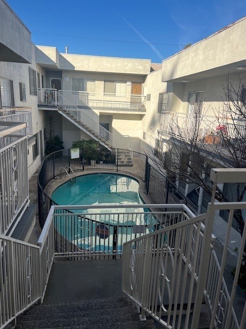 A small pool is surrounded by a metal fence.