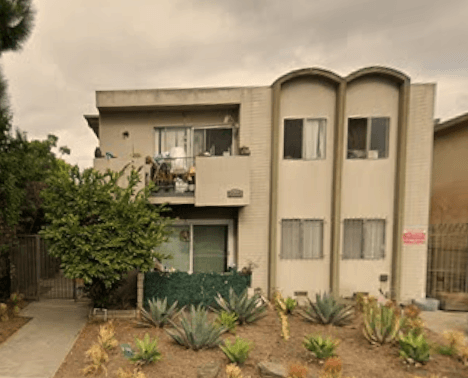 A house with a balcony and a garden in front.
