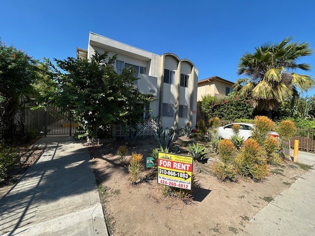 A house is for rent with a sign in front of it.