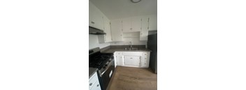 A kitchen with white cabinets and a black stove top oven.