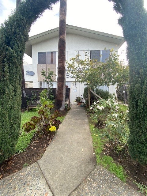 A white house with a grey walkway in front.