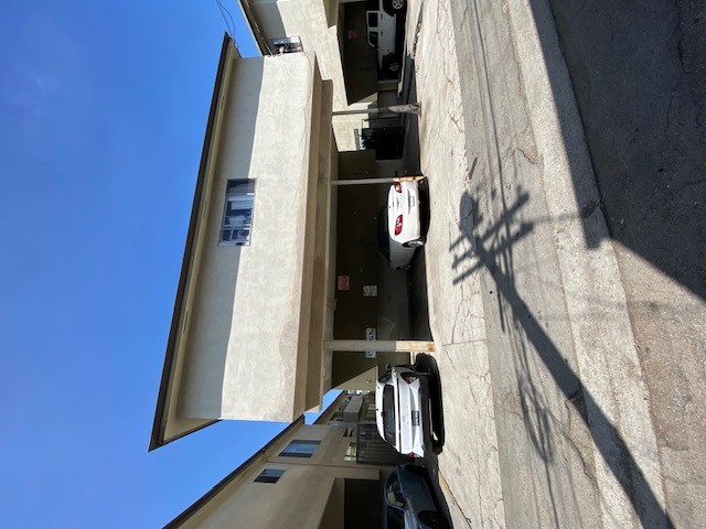 A car is parked on the street in front of a building.