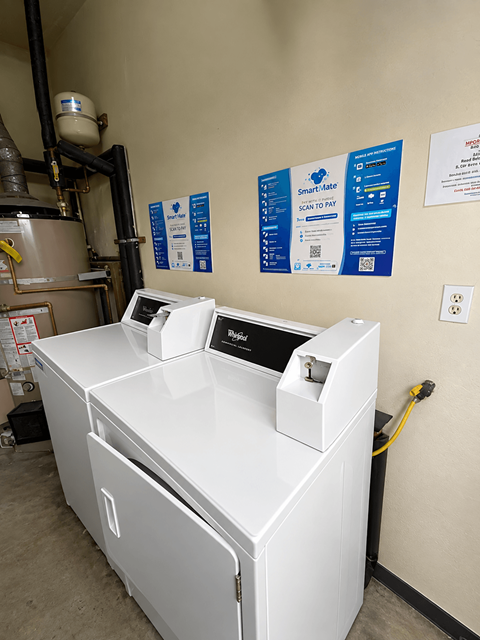 A white washing machine with a dryer on top of it.