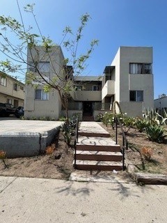 A concrete building with a tree in front of it.