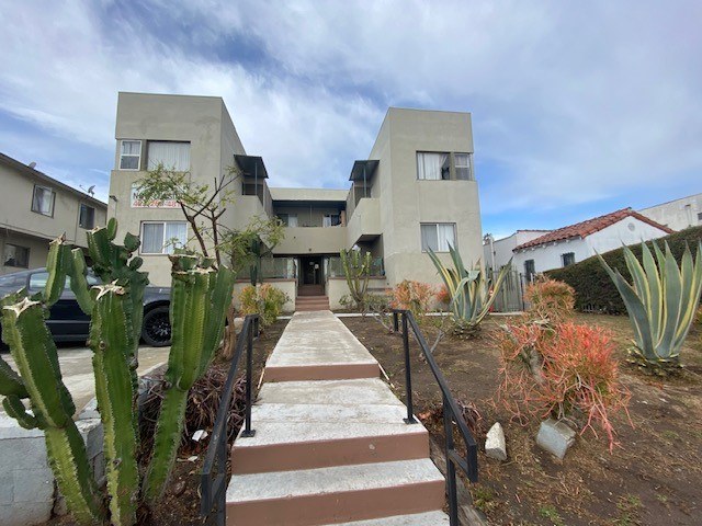 A modern building with a concrete facade and a staircase leading to the entrance.