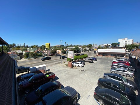 A parking lot with cars and a yellow sign in the distance.