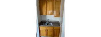 A kitchen with wooden cabinets and a granite countertop.