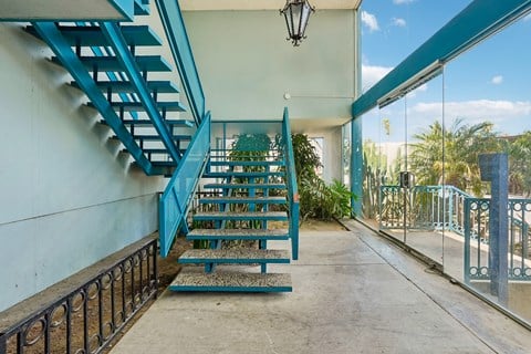 A blue staircase with a black railing.