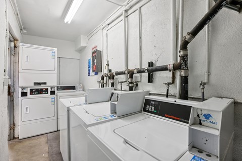 A machine shop with a white floor and walls, and a variety of machines and tools.