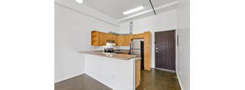 A kitchen with white walls and a brown counter top.