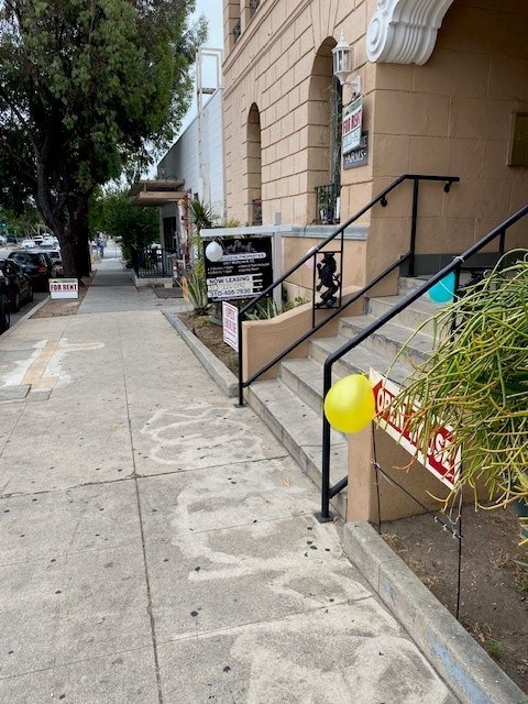 A yellow balloon is tied to a sign on a staircase.
