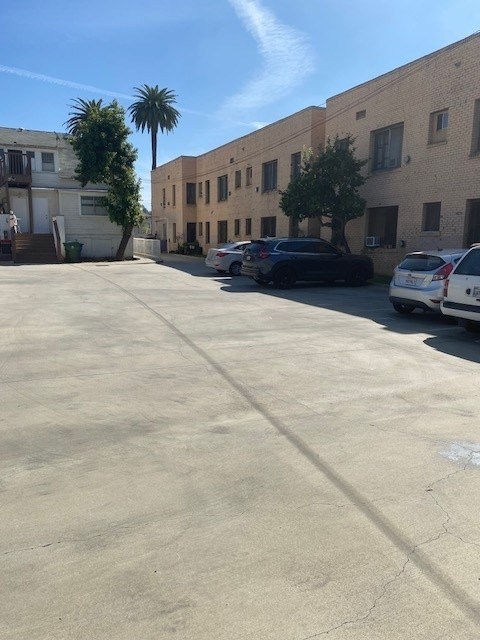 A parking lot with cars and buildings on the side.