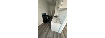 A kitchen with a white fridge and a white counter top.