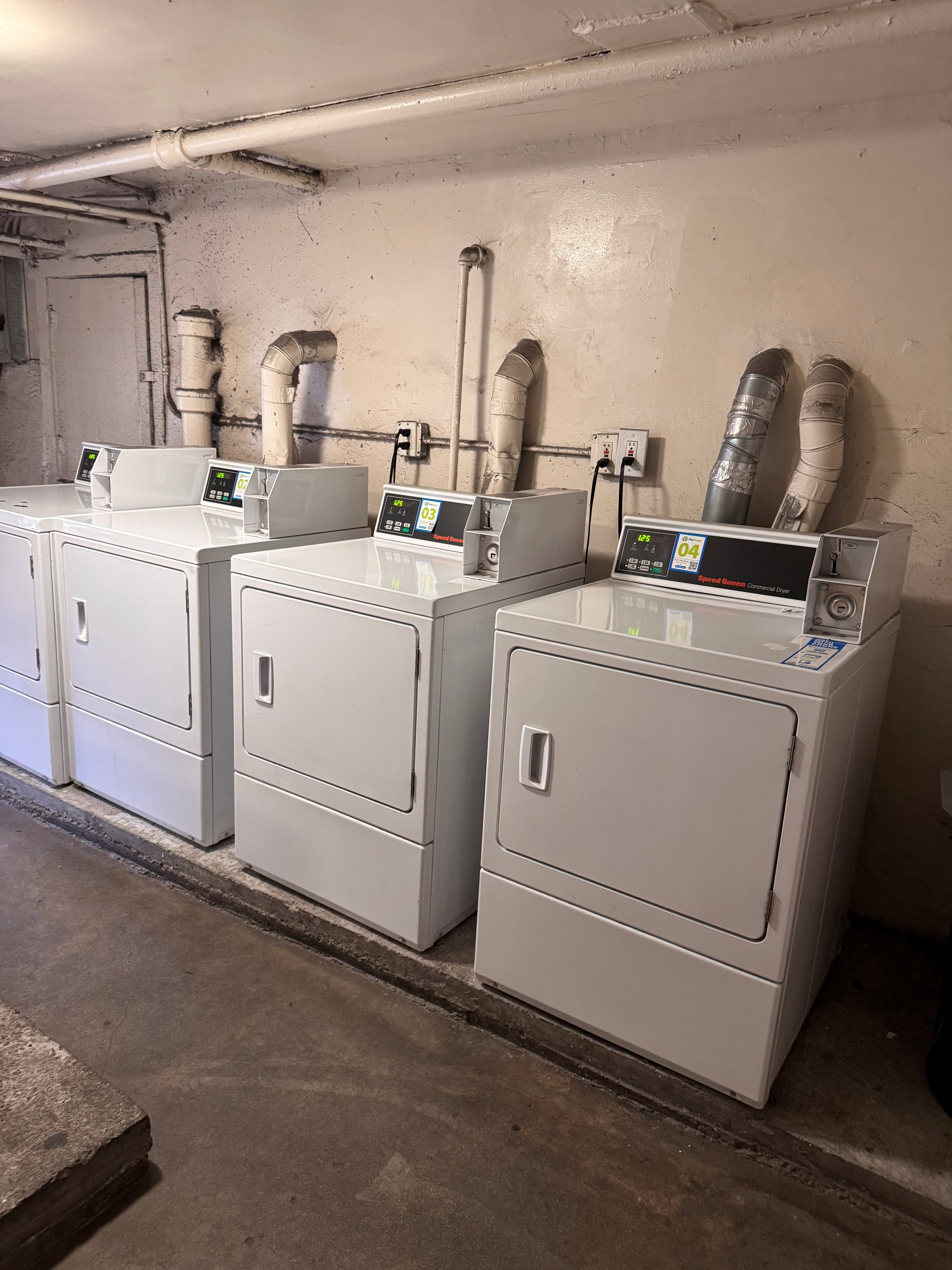 A row of industrial machines are lined up against a wall.
