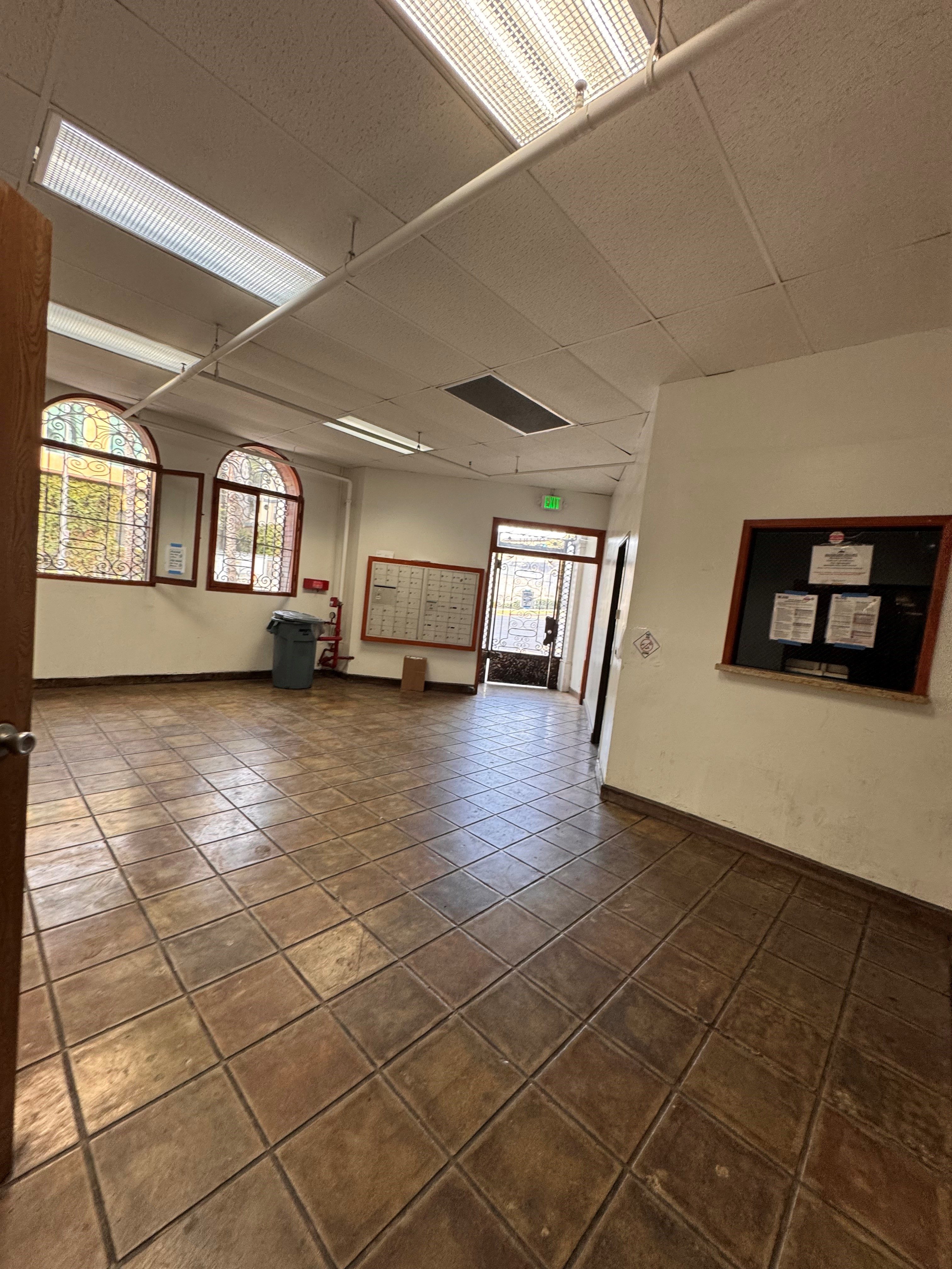 A room with brown tile flooring and white walls.