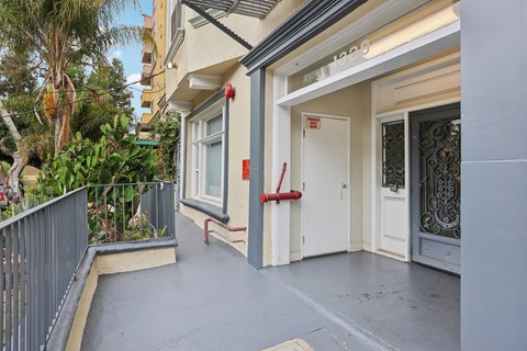 A balcony with a metal railing and a red rope tied to a post.