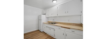 A kitchen with white cabinets and a wooden countertop.