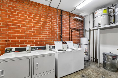 A room with a red brick wall and a white tank.