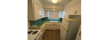 A kitchen with white cabinets and a tiled backsplash.