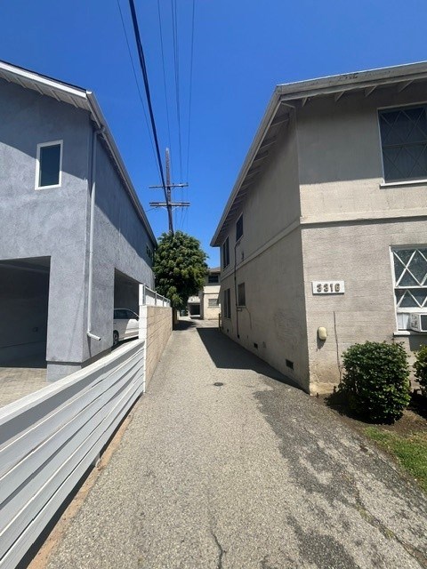 A narrow street between two buildings with a clear blue sky above.