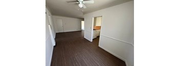 A room with a ceiling fan and wooden flooring.