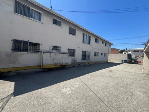 A white building with a yellow line on the ground in front of it.
