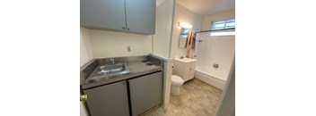 A small, clean, and well-organized kitchen with a sink, stove, and refrigerator.