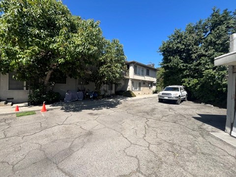 A car is parked in a driveway with orange cones around it.
