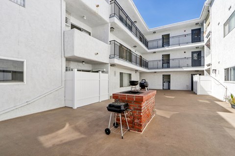 A patio with a BBQ grill in the middle of it.