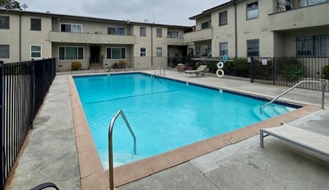 A small pool in a courtyard surrounded by apartment buildings.