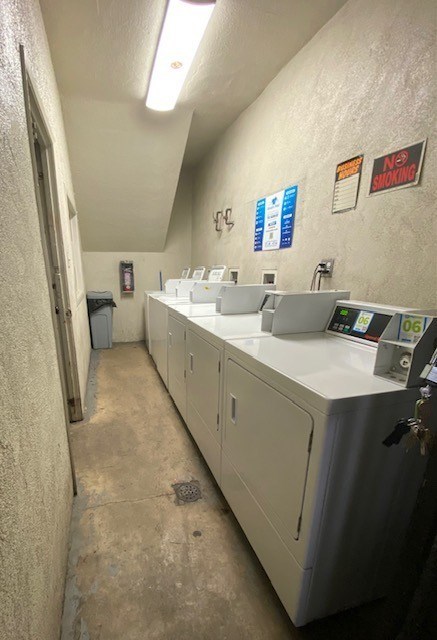 A long white sink is in a room with a sign that says no smoking.