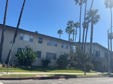 A building with a white facade and a green lawn in front.