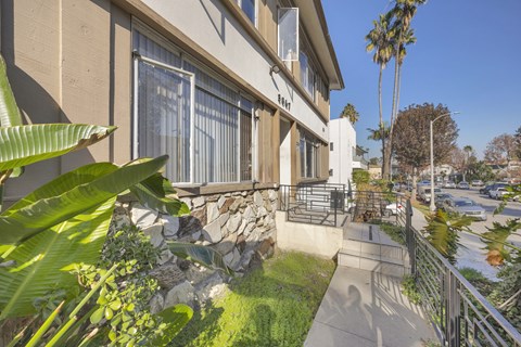 A house with a stone wall and a fence.