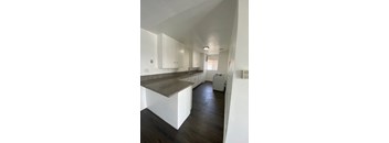 A kitchen with white cabinets and a granite countertop.