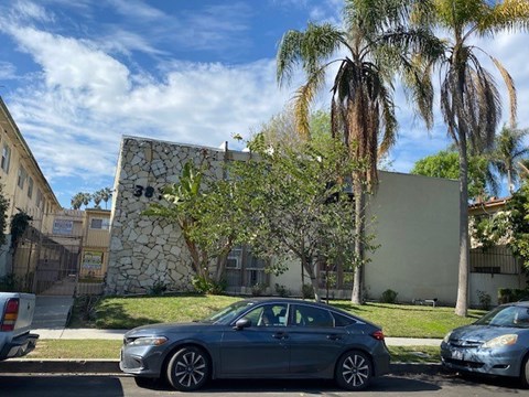 A grey car is parked on the side of a street.