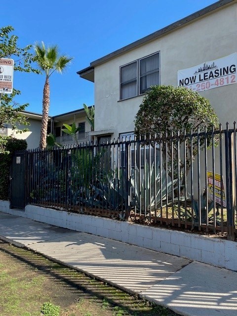 A house with a sign that says "NOW LEASING" and a phone number.