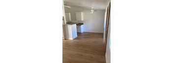 A kitchen with a refrigerator, microwave, and a fan.