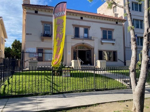 A building with a "Now Renovate" banner in front of it.