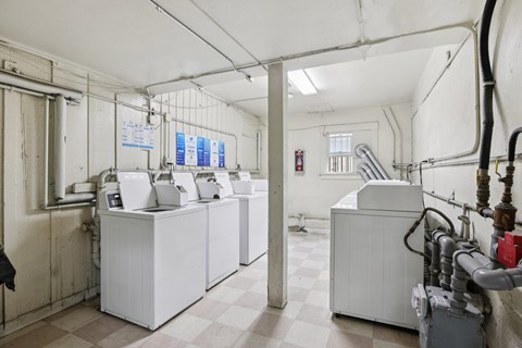 A room with white appliances and pipes.
