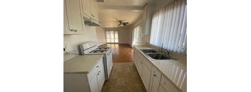 A kitchen with white cabinets and a tiled floor.